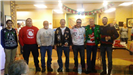 A line of men wearing ugly holiday sweaters