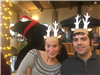 Two people wearing paper reindeer antlers