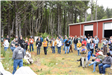A group of people standing outside in front of a large garage