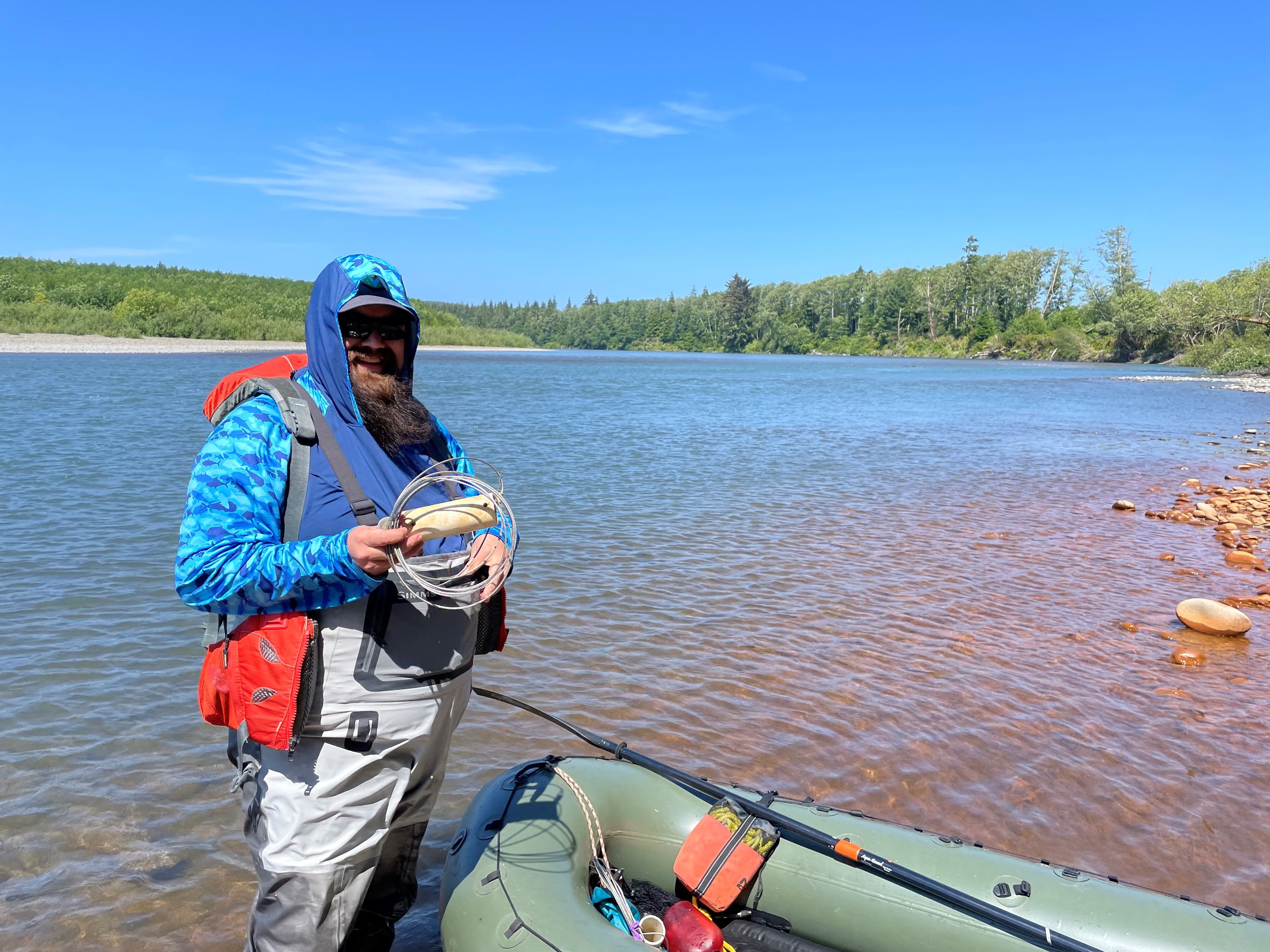 Person standing in a boat on a lake.