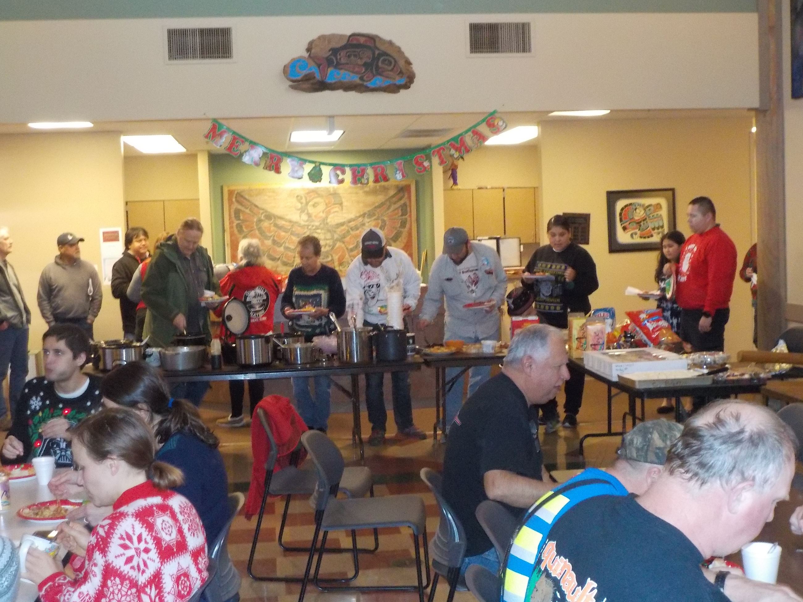 People getting food at a potluck buffet