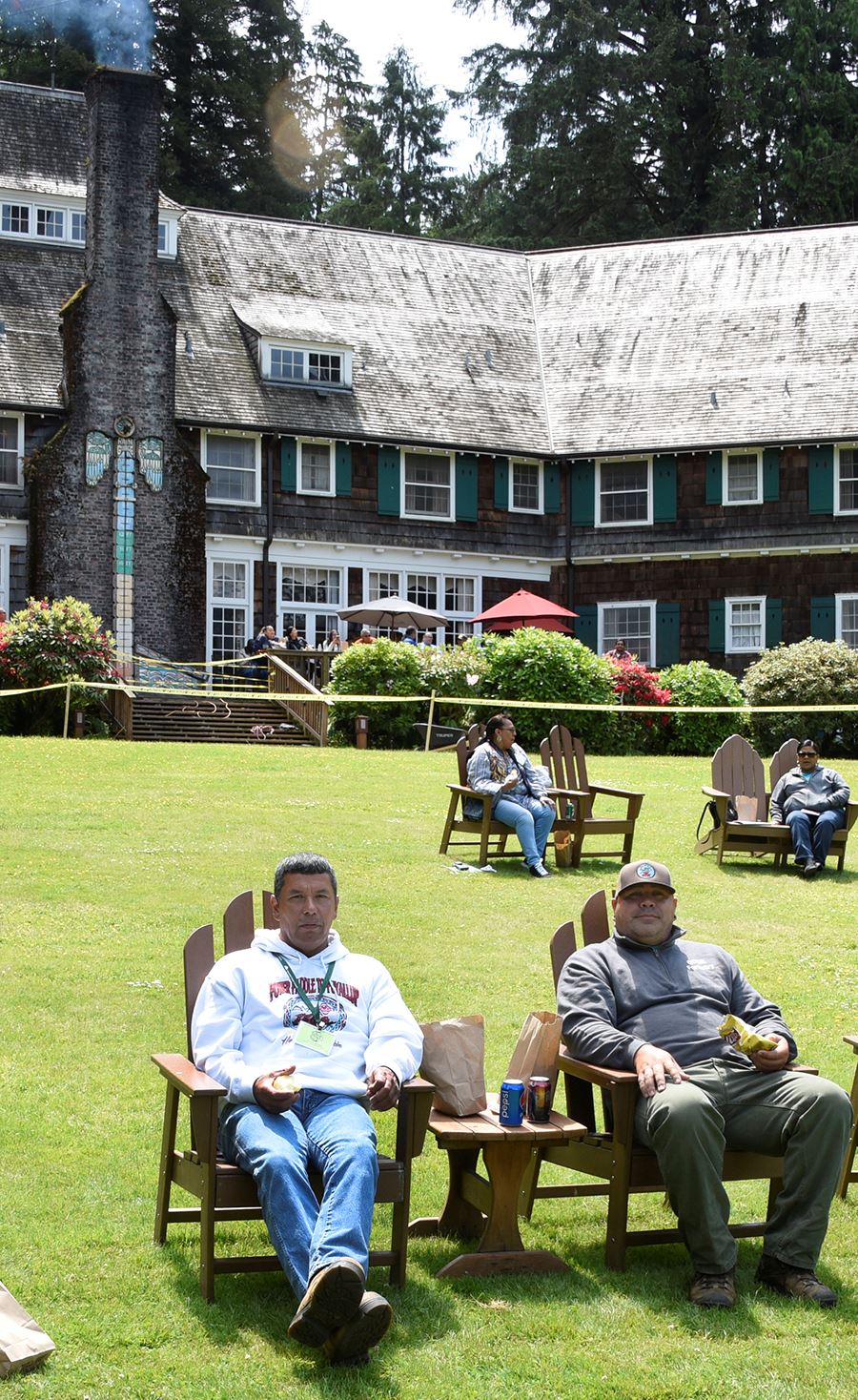People sitting in wooden chairs on the lawn