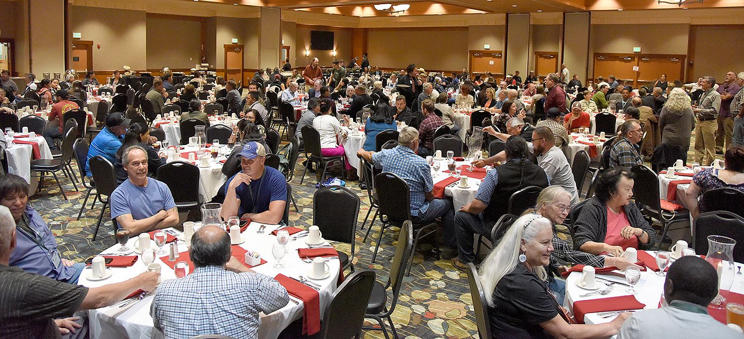 A group of people at tables in a conference room