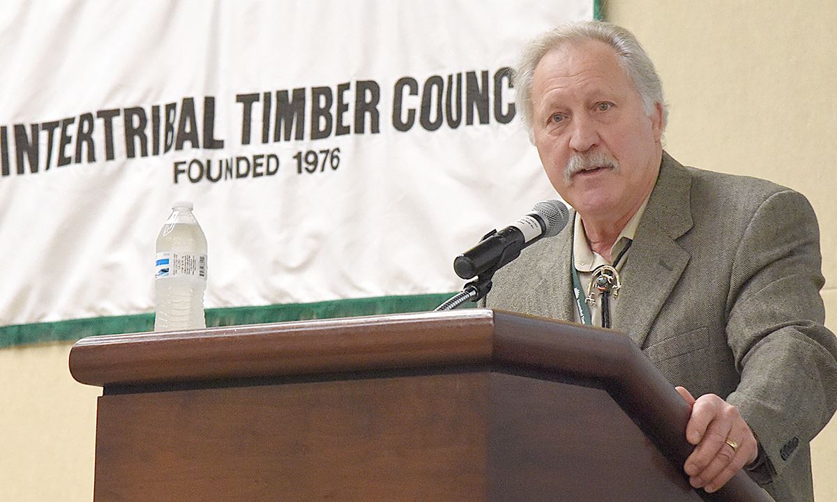 A man at a podium speaks into a microphone
