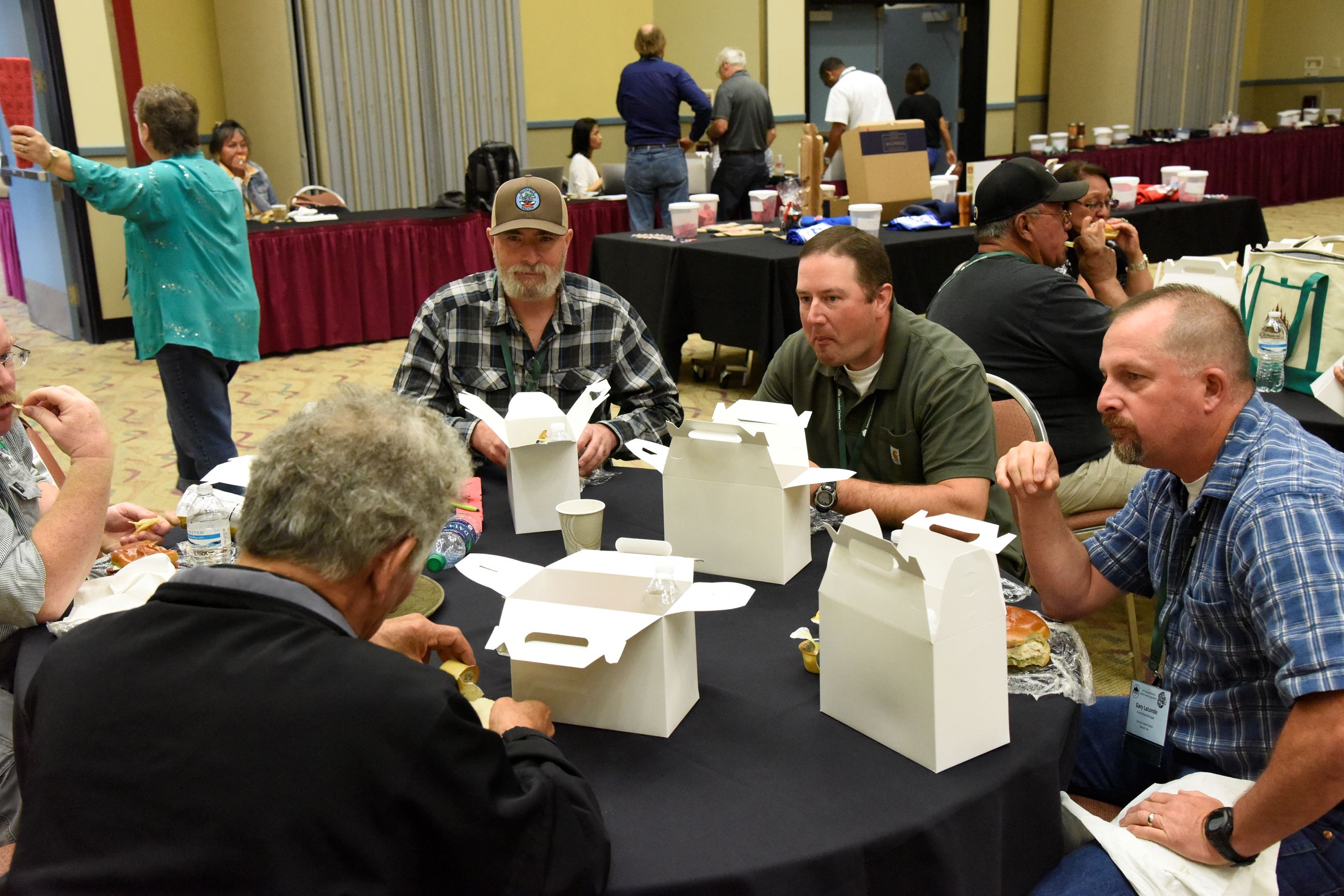 People at a table eating boxed lunches