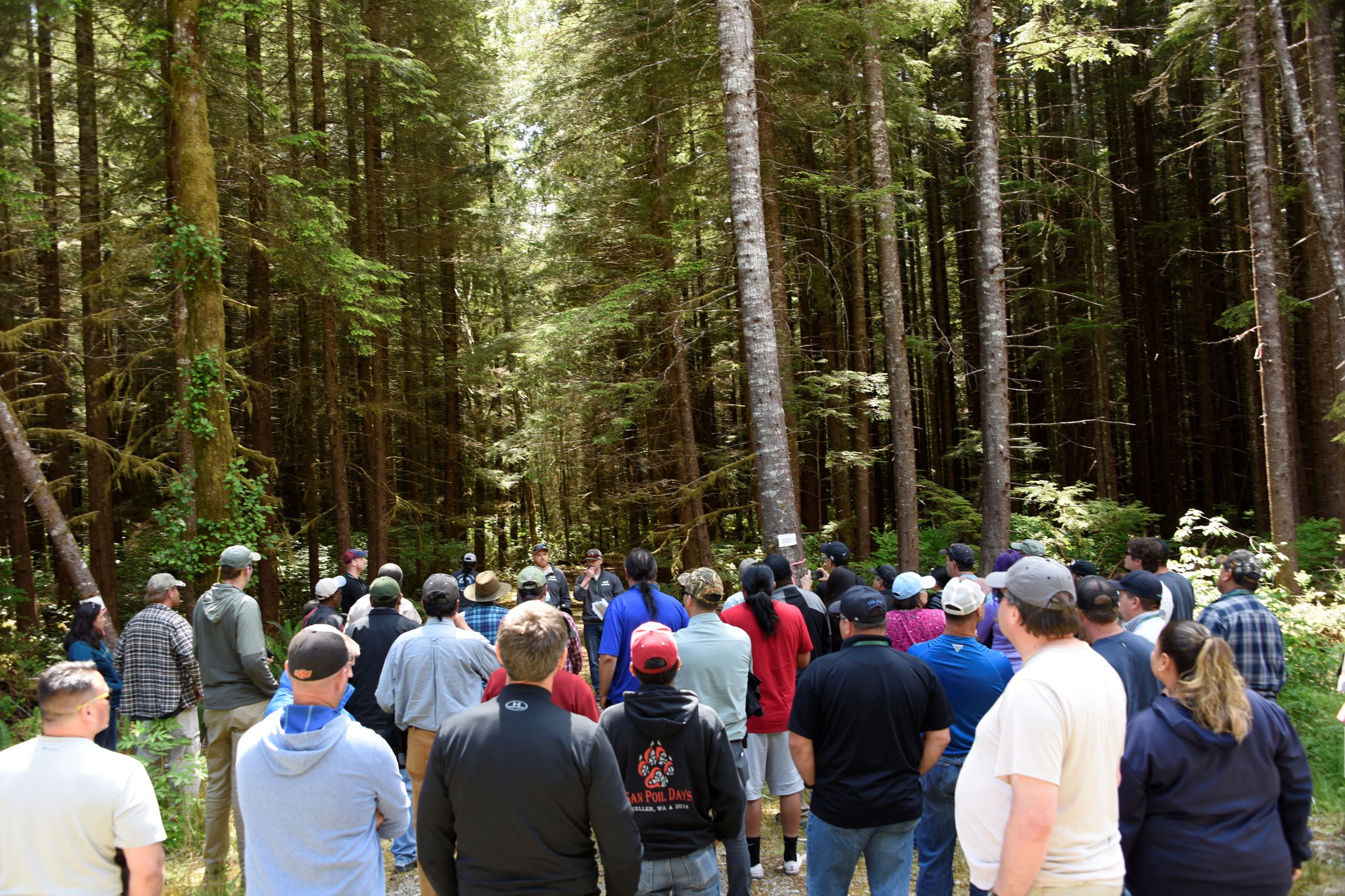 A group of people standing in front of a forest