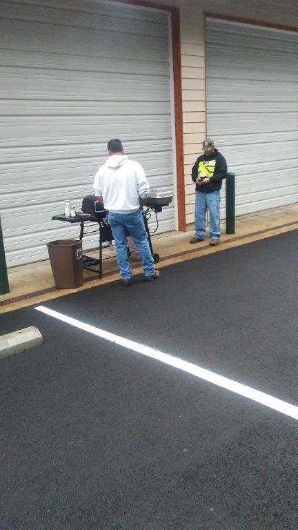 Two men grilling in a parking lot