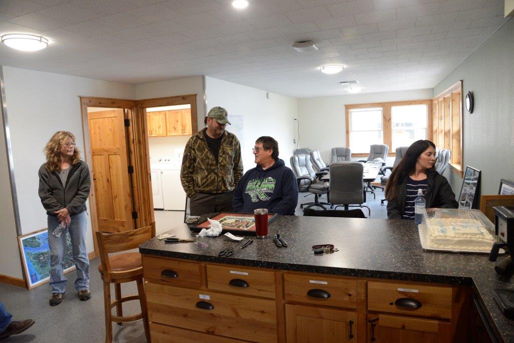 4 people sitting around a counter with a cake on top