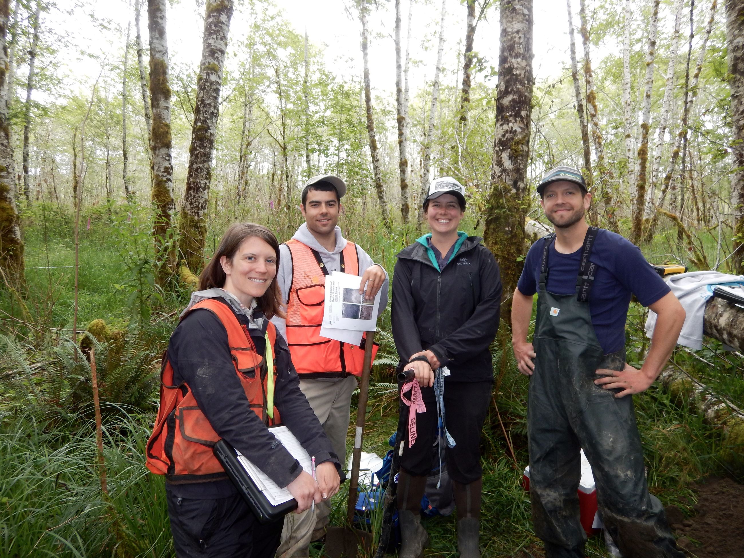 Group of people posing with clipboards and dressed in field clothes