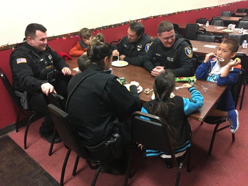 Officers sitting at a diner table with a children